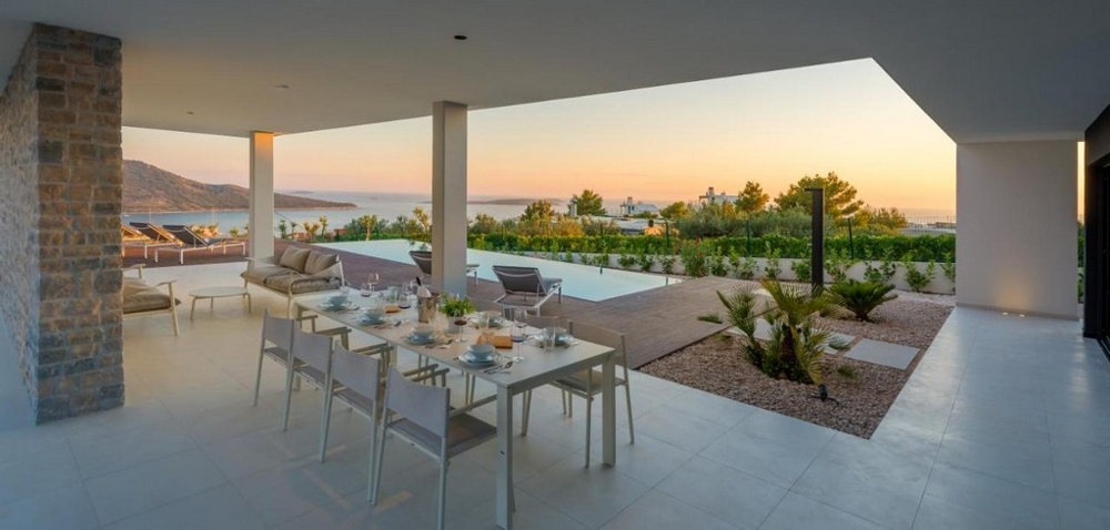 Terrasse couverte avec table à manger et vue sur la mer