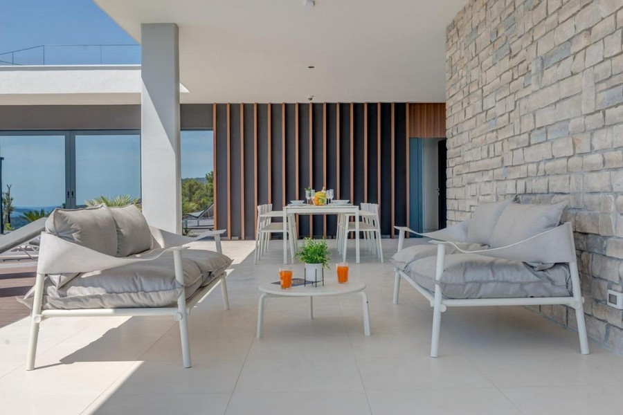 Coin salon sur la terrasse avec mur en pierre naturelle