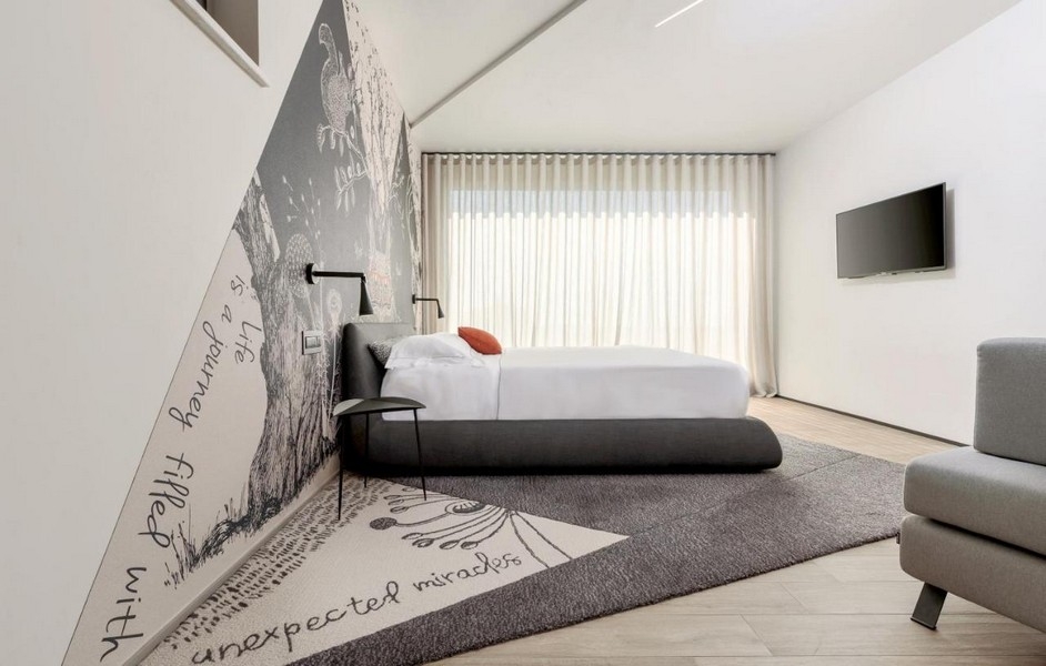 Chambre avec décoration murale et grande fenêtre