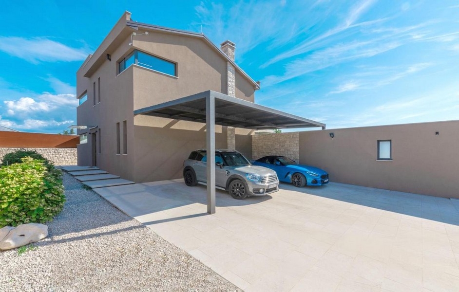 Carport couvert avec deux voitures devant la villa