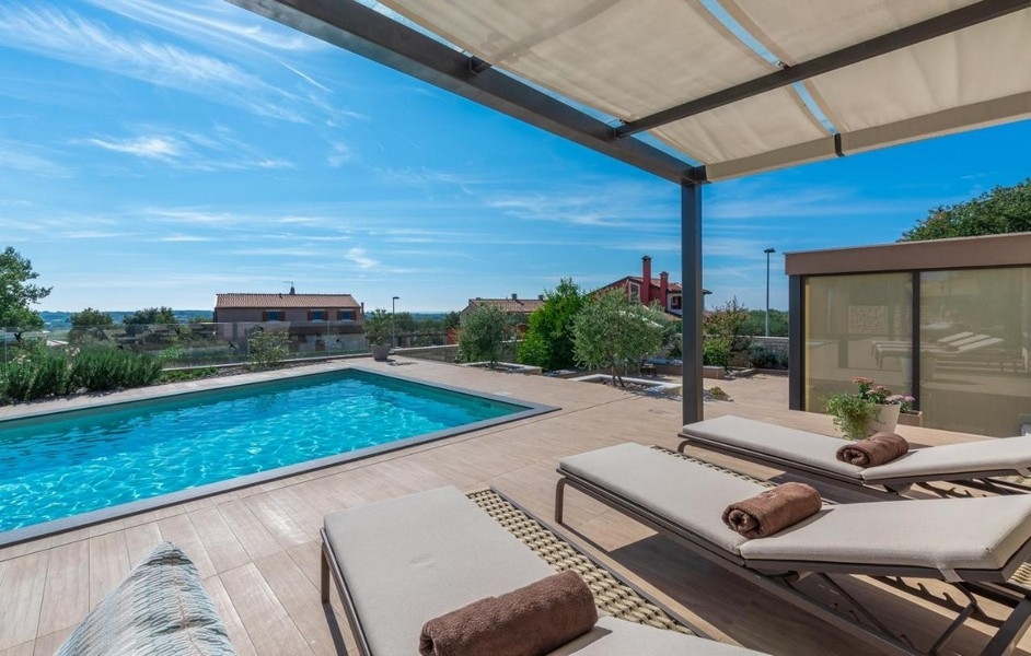 Piscine avec bains de soleil et vue sur les environs