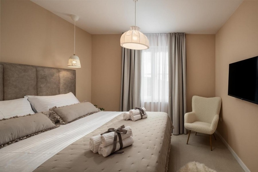 Chambre avec lit double, TV et fauteuil