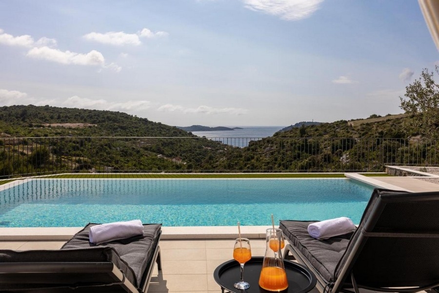 Piscine à débordement avec vue mer et bains de soleil