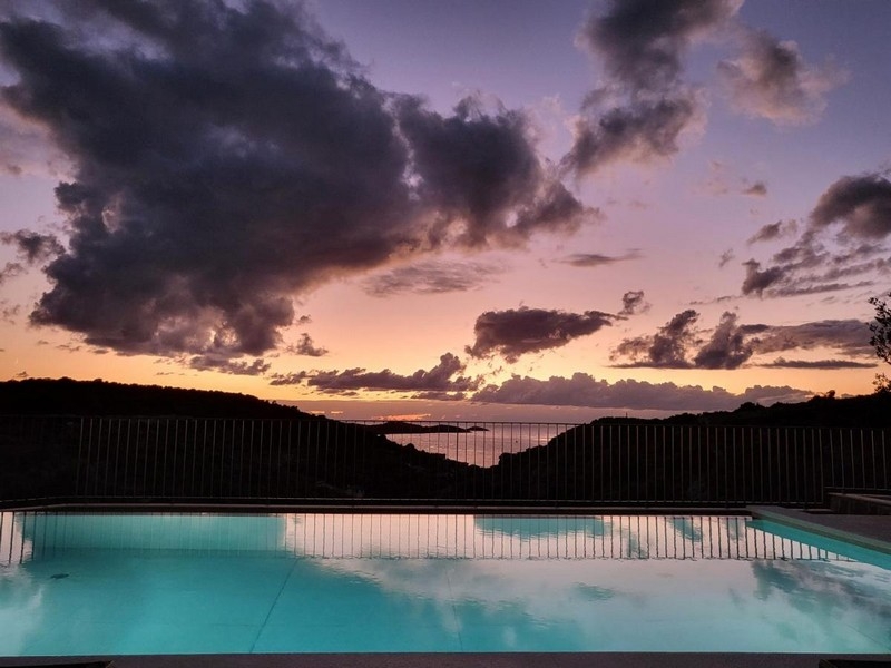 Piscine avec vue sur le coucher de soleil sur la mer