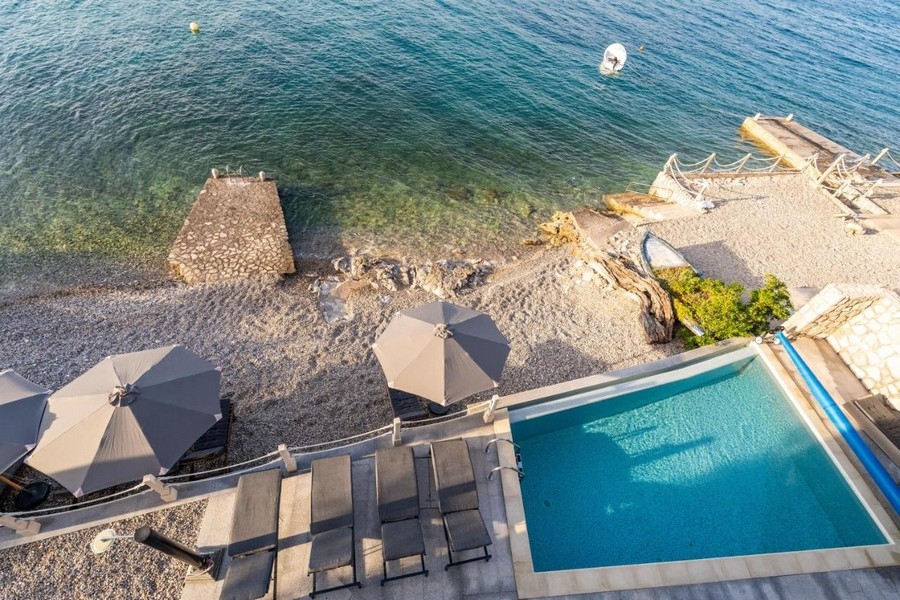 Vue du dessus sur la piscine, les parasols et le ponton de baignade