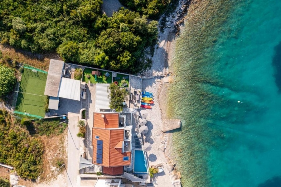 Vue aérienne de la maison avec piscine et kayaks sur la plage de galets