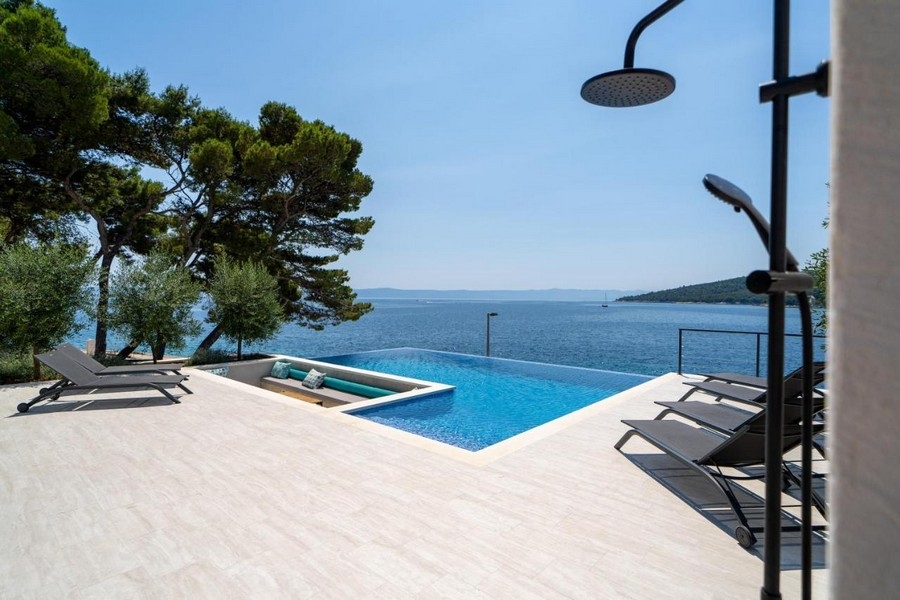 Piscine à débordement avec douche extérieure et vue mer