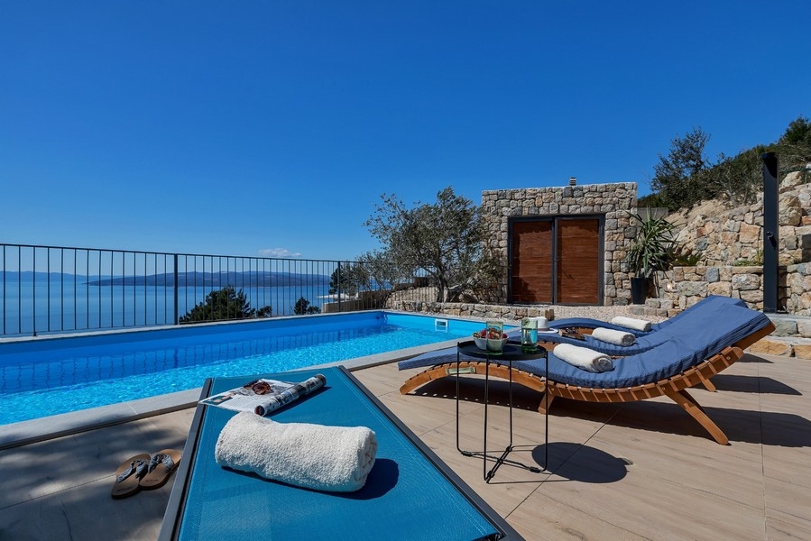 Piscine avec chaises longues et vue mer