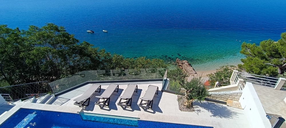 Maison jumelée au-dessus de la plage de galets avec piscine et transats