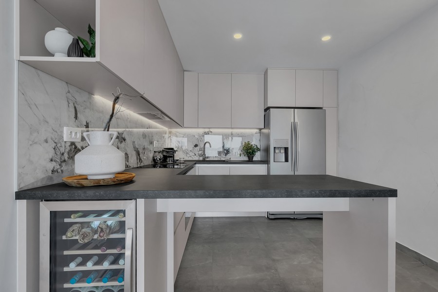Cuisine équipée moderne avec îlot et cave à vin