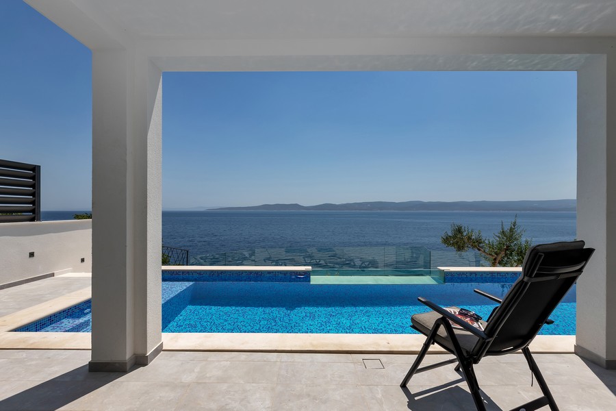 Terrasse couverte avec piscine et vue mer