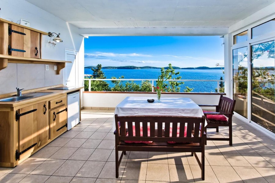 Terrasse ouverte avec table à manger et superbe vue mer