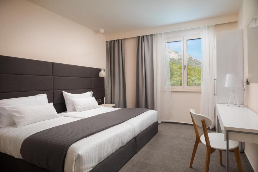 Chambre lumineuse avec lit double et vue sur les montagnes