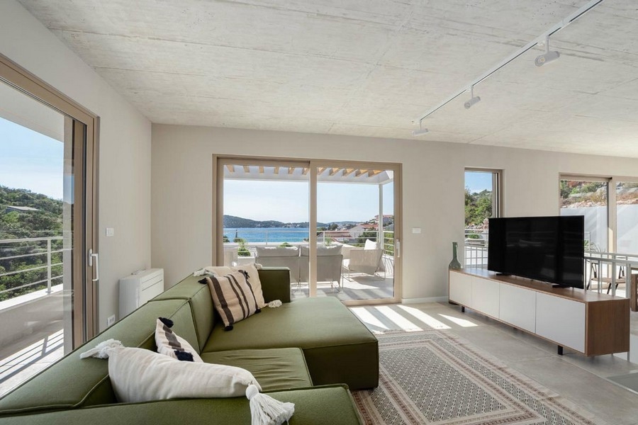 Séjour avec canapé et sortie sur la terrasse avec vue mer