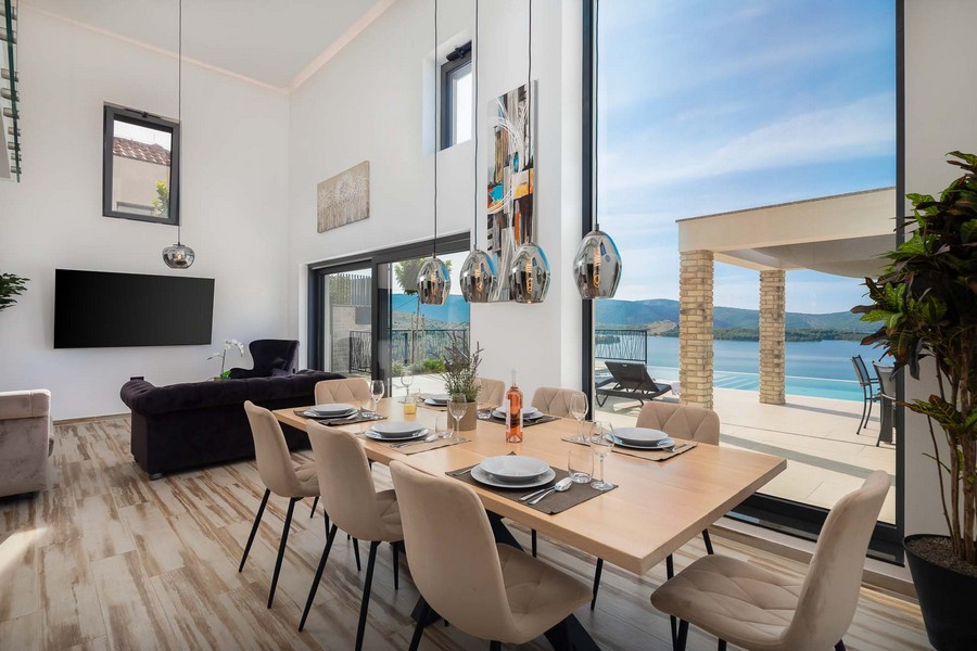 Coin repas avec grande façade vitrée et vue sur la mer