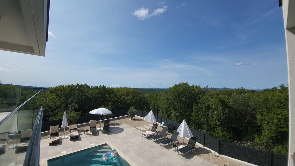 Vue sur l'espace piscine avec bains de soleil et parasols