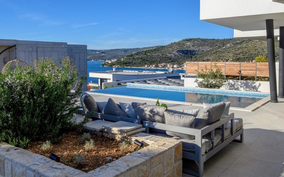 Terrasse avec coin lounge et piscine à débordement, vue mer