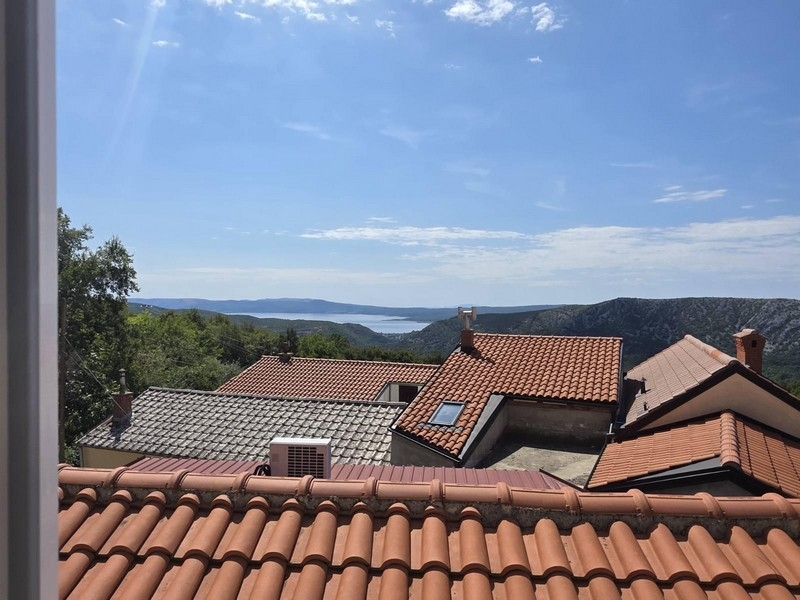 Vue par-dessus les toits de tuiles du village sur la baie