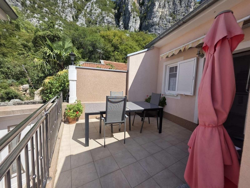 Terrasse avec table, chaises et vue sur les rochers