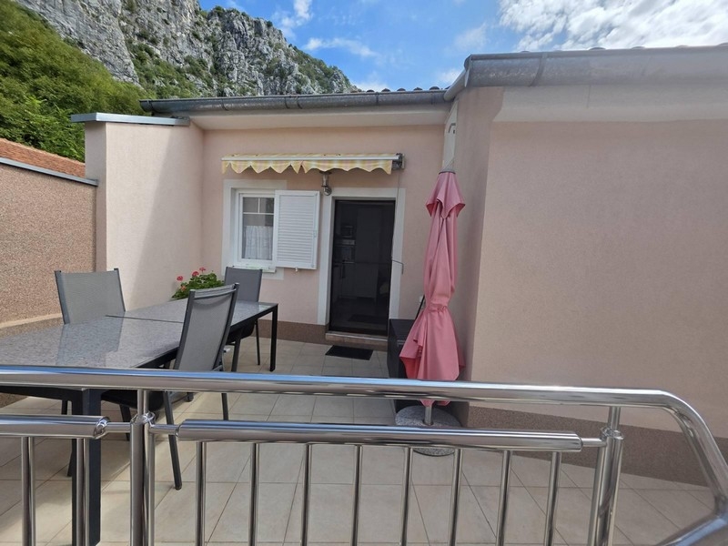 Terrasse avec store, coin salon et parasol