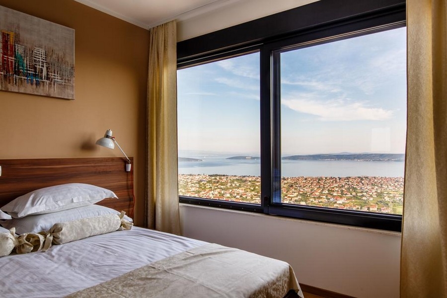 Chambre avec vue mer à travers une grande fenêtre panoramique