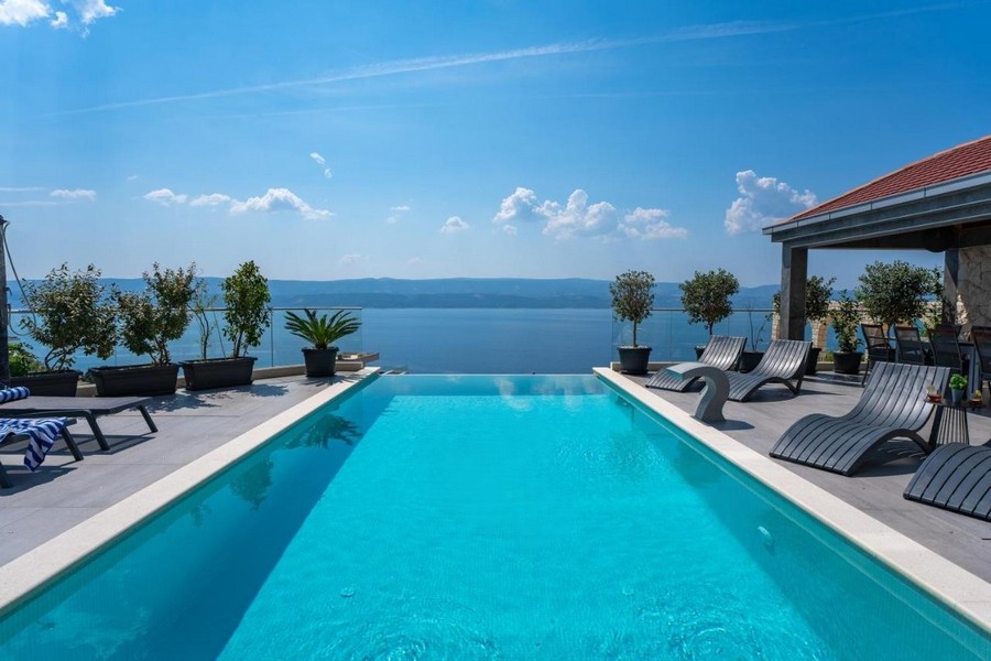 Piscine à débordement avec vue mer panoramique et bains de soleil