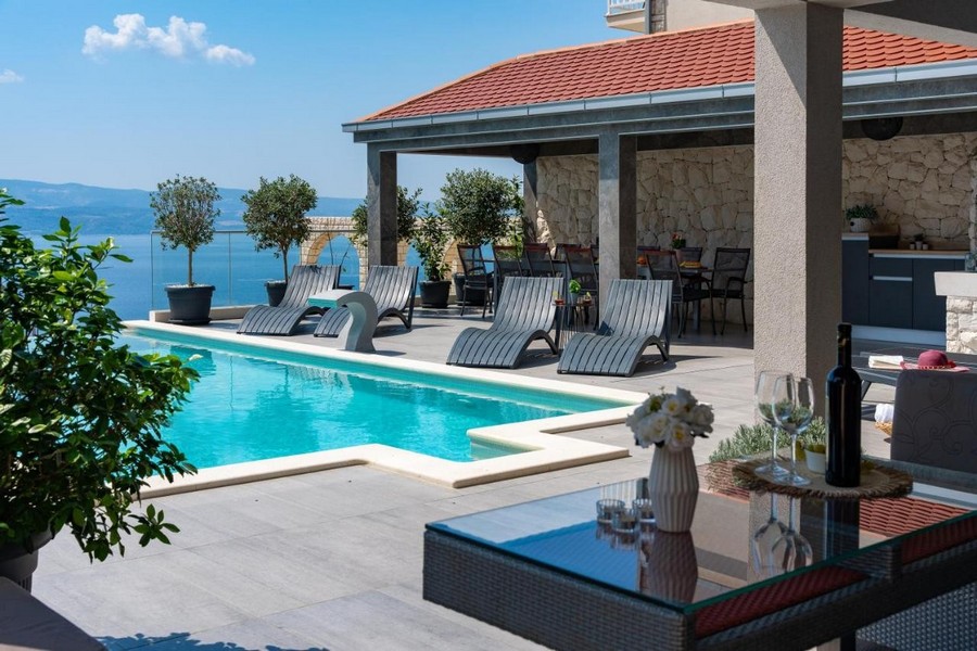 Terrasse de la piscine avec bains de soleil et coin repas couvert