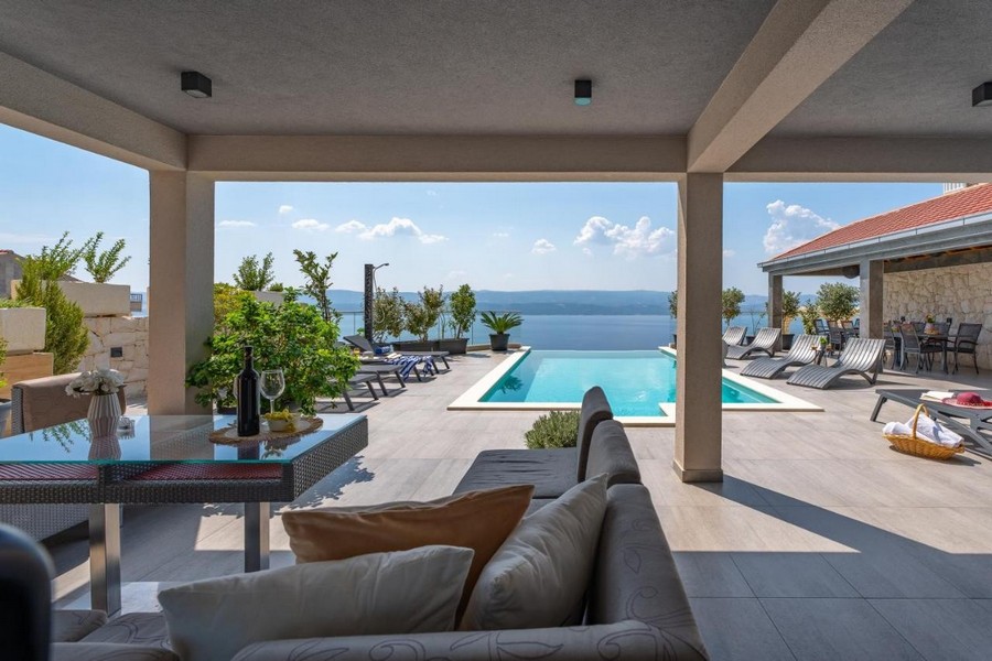 Terrasse couverte avec vue sur la piscine et la mer