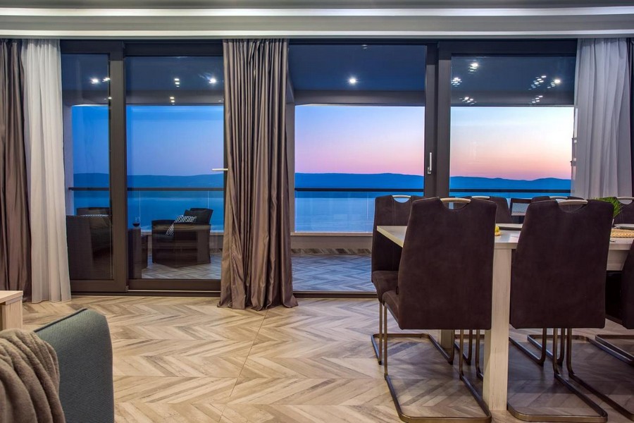 Coin repas avec vue mer à travers la grande façade vitrée