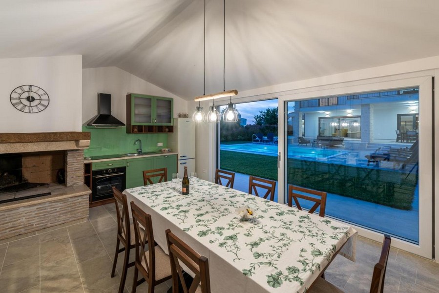Espace repas dans la dépendance avec cheminée et accès au jardin