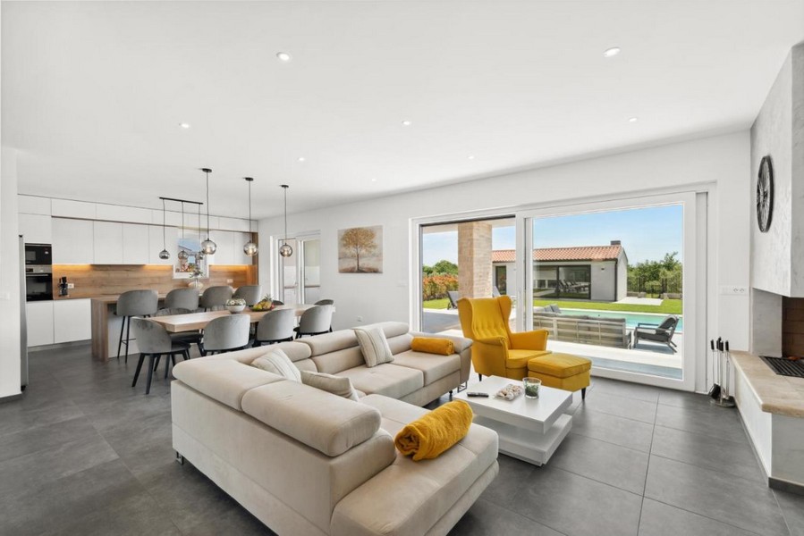 Salon lumineux avec accès à la terrasse et vue sur la piscine