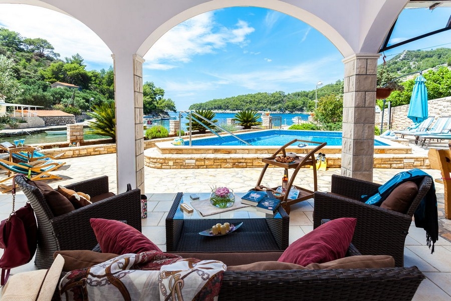 Terrasse couverte avec vue sur la piscine et la mer