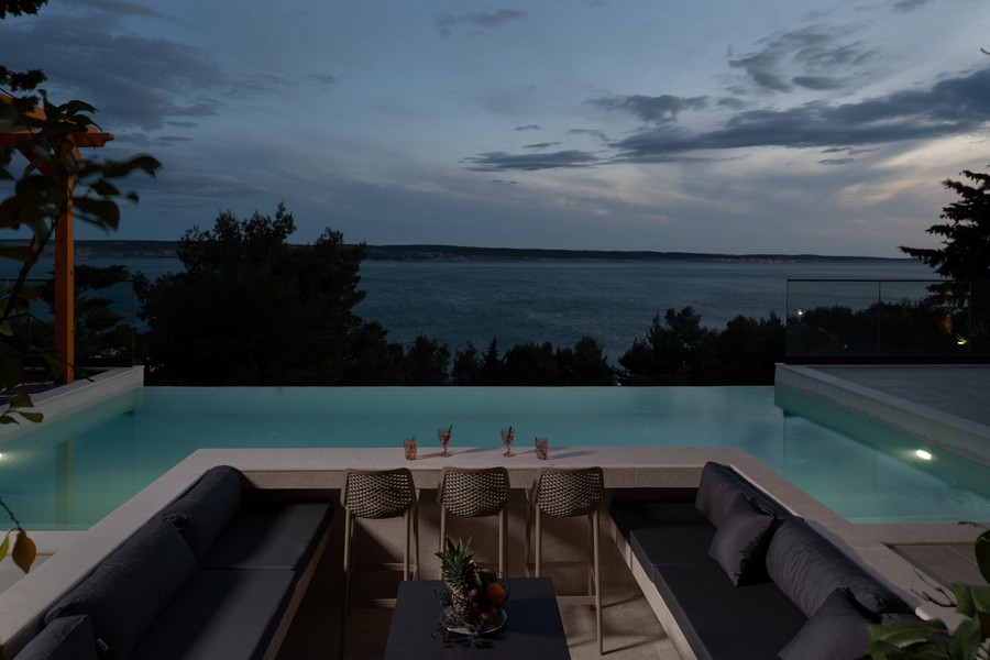 Piscine à débordement avec coin salon et vue sur la mer