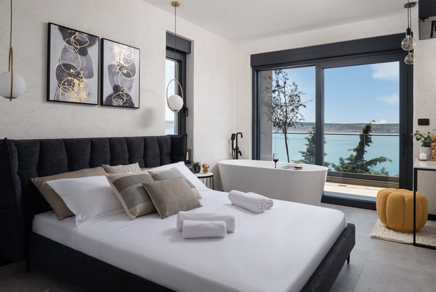 Chambre avec lit double, baignoire îlot et vue mer
