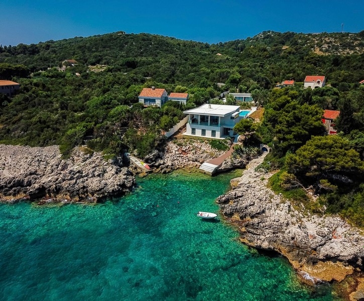 Villa blanche au-dessus de la crique rocheuse à l'eau turquoise