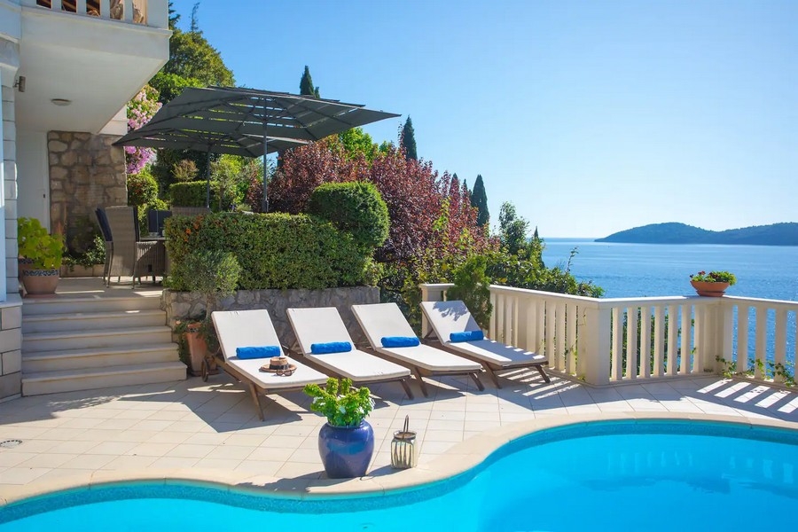 Solarium avec piscine, transats et vue mer