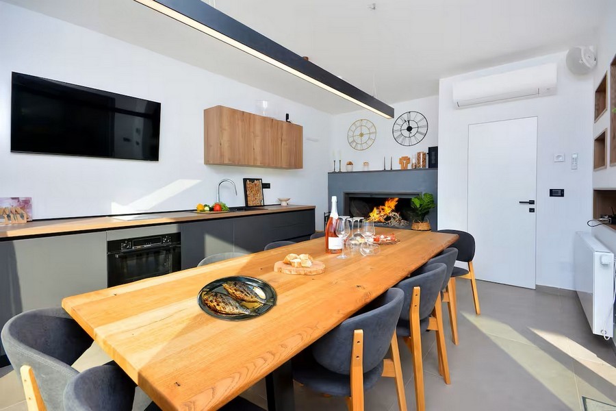 Coin repas avec grande table en bois et escalier intérieur