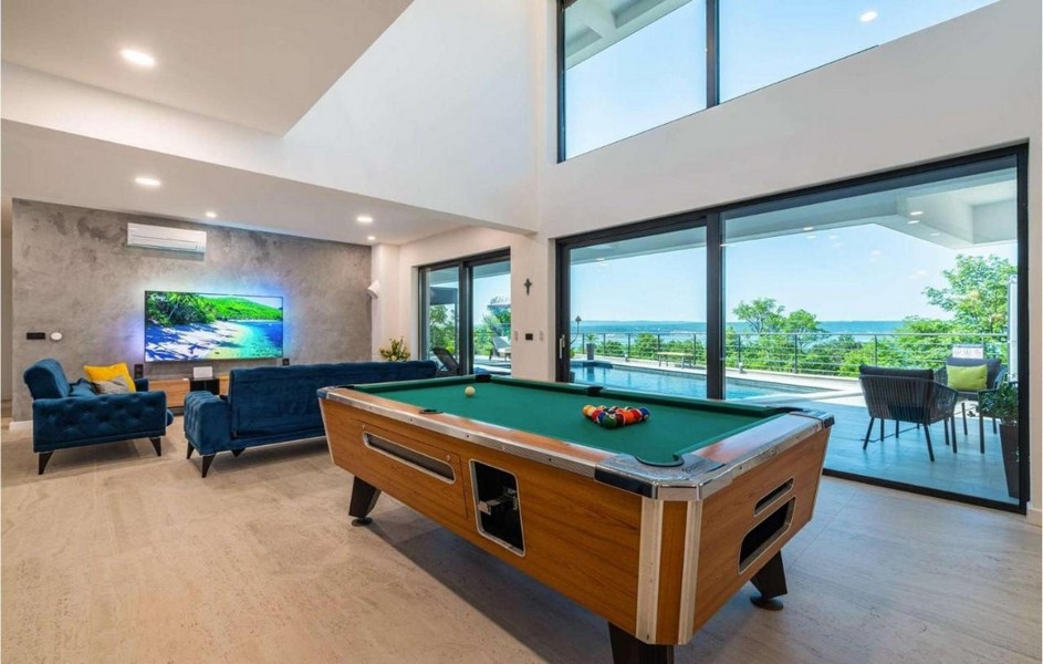 Séjour avec table de billard et vue sur la piscine