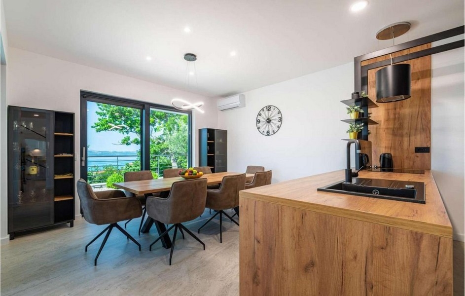 Coin repas avec table en bois et vue mer