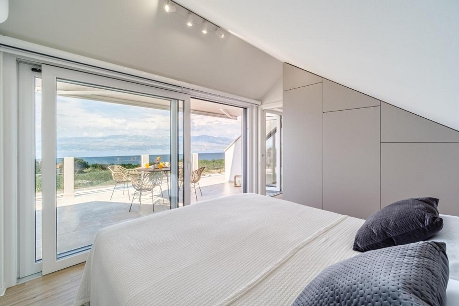 Chambre à l'étage avec lit double et accès à la terrasse