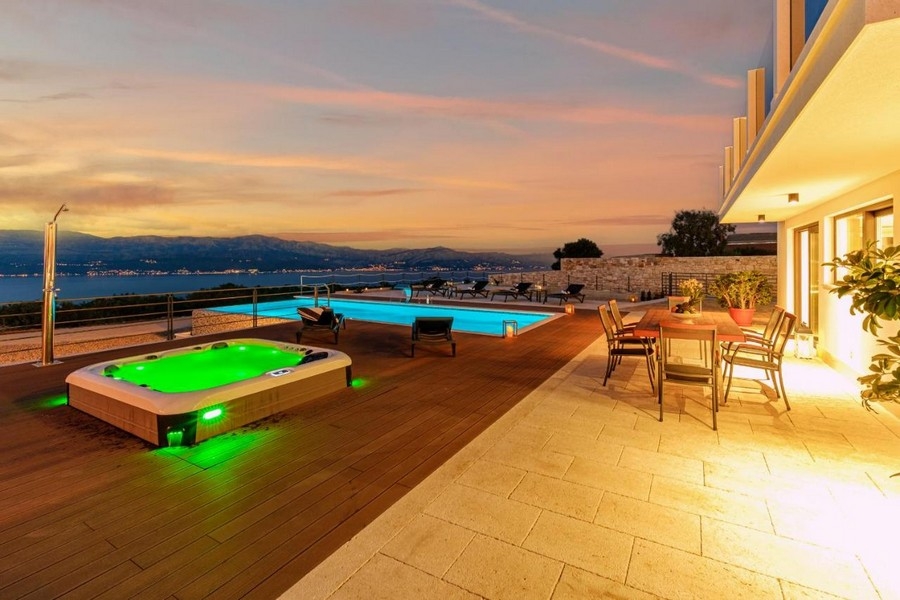 Terrasse avec jacuzzi et piscine, vue sur la mer au coucher du soleil