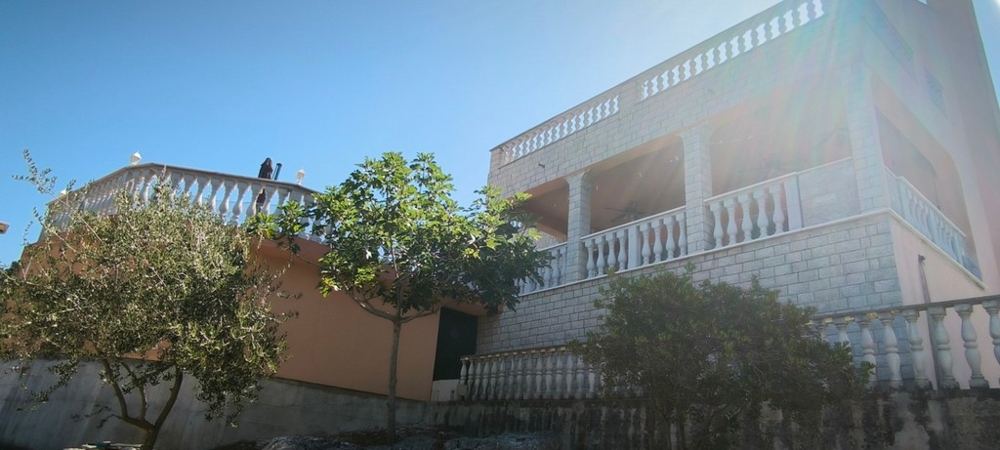Maison en pierre avec balcon et terrasse, vue extérieure