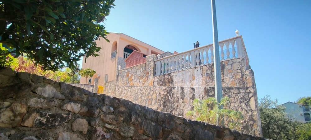 Maison sur un mur en pierre surélevé avec terrasse