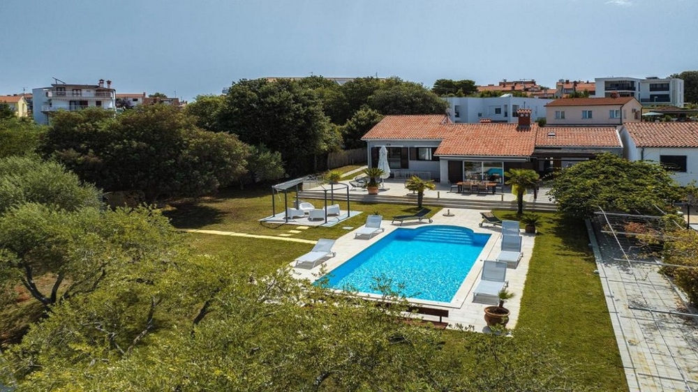 Vue aérienne de la maison et de la piscine dans le grand jardin