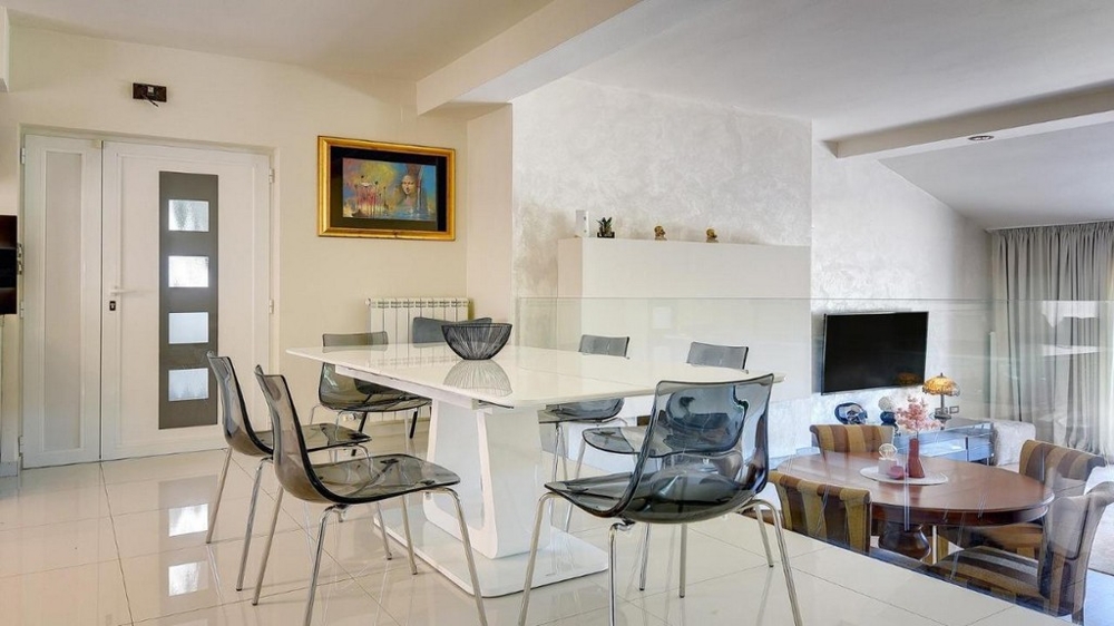 Coin repas moderne avec table blanche et garde-corps en verre