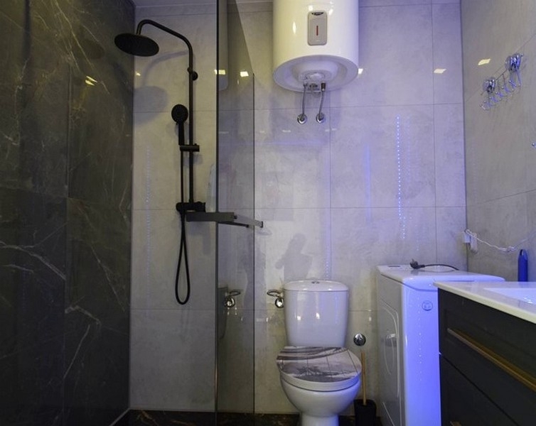 Salle de bains moderne avec douche et lave-linge