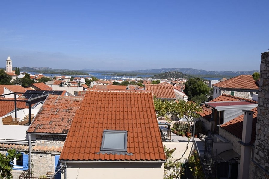 Vue par-dessus les toits de tuiles sur le port et le clocher