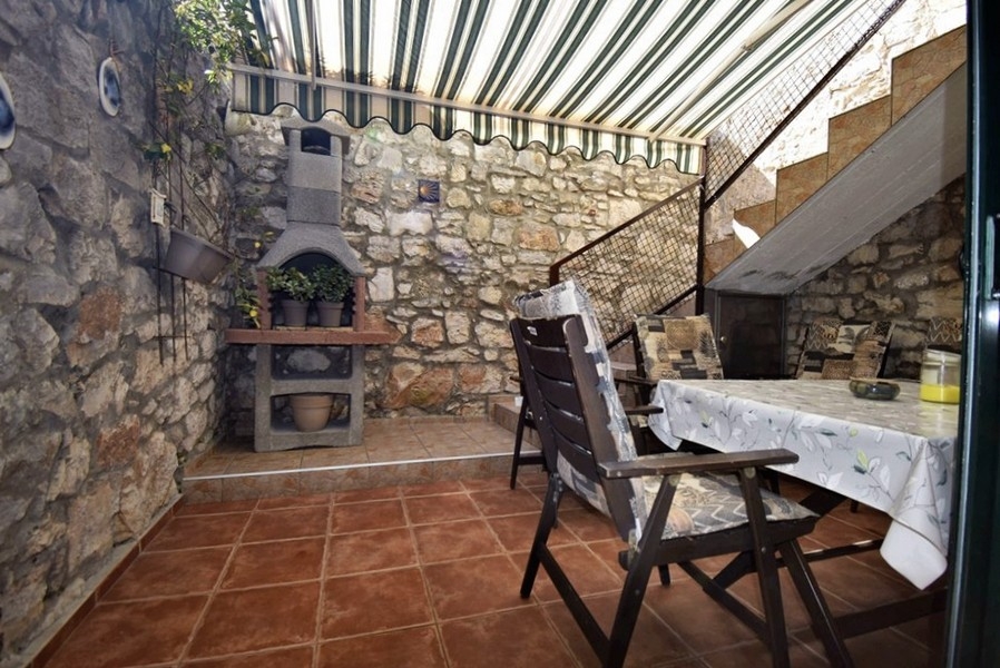 Terrasse couverte avec grill en pierre et coin salon