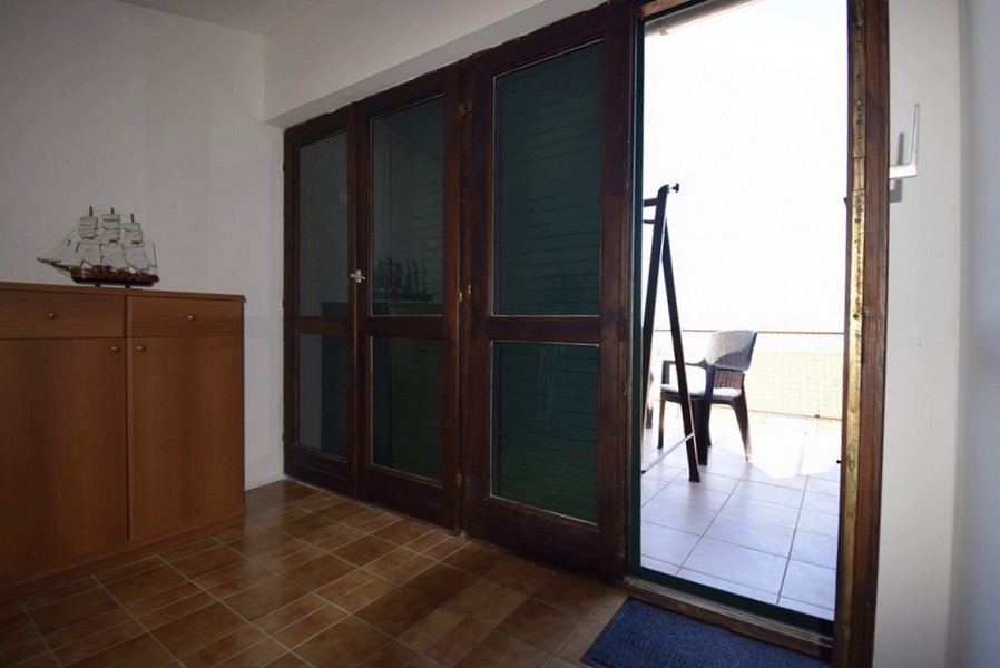 Accès à la terrasse avec vue mer à travers de grandes portes vitrées