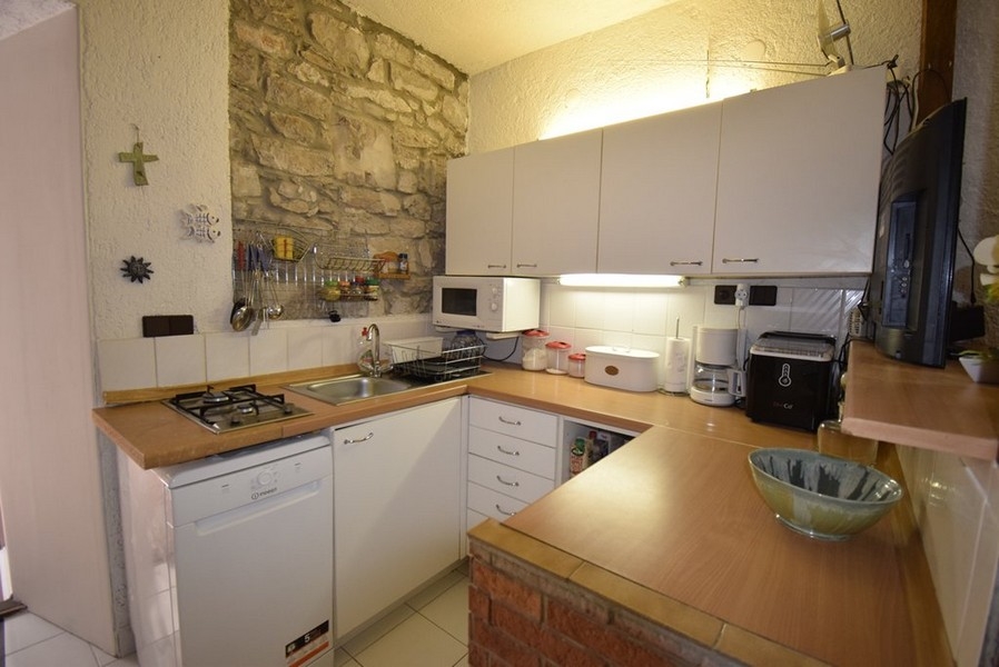 Cuisine avec cuisine équipée et mur en pierre